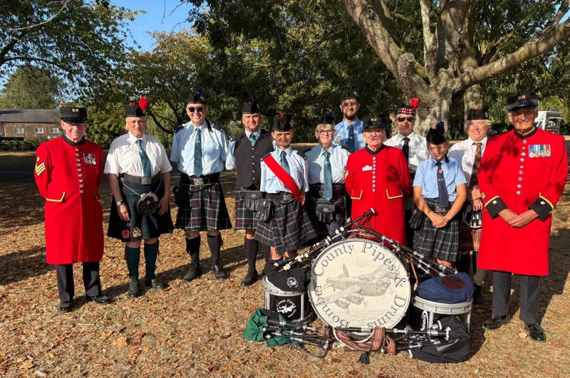 The band with Chelsea pensioners in red coats, gathered round the crested bass drum